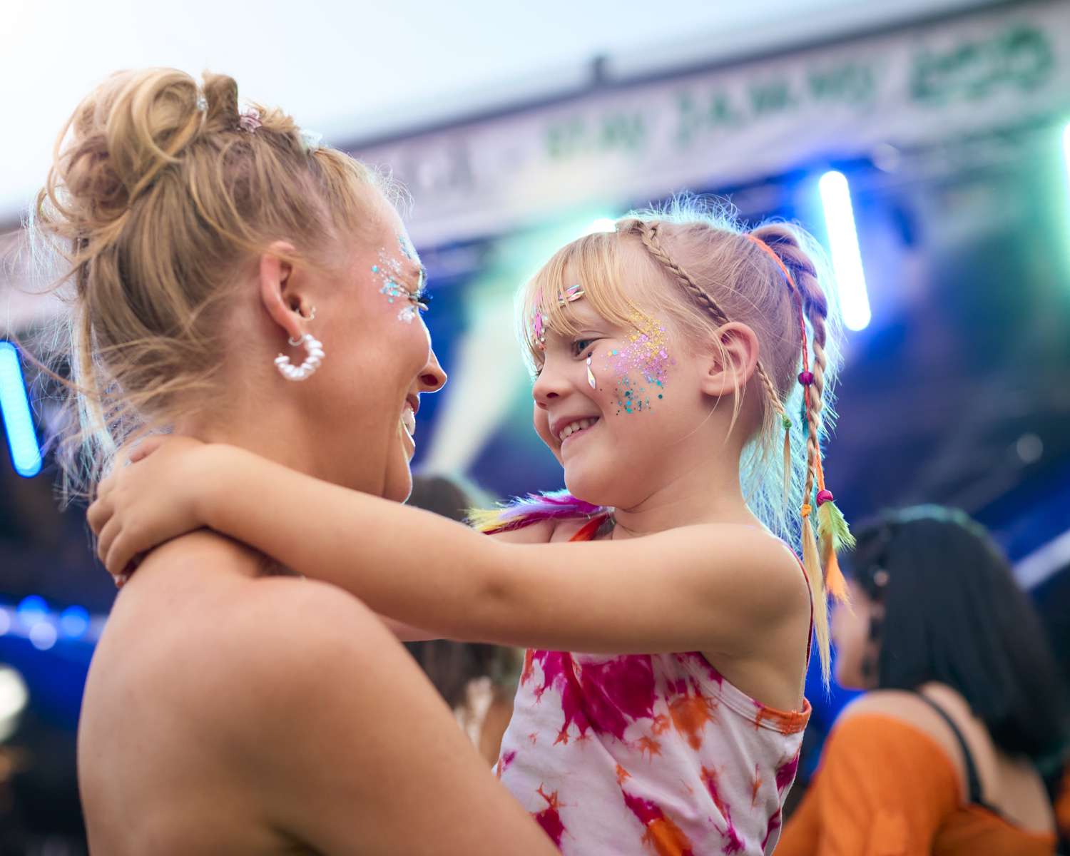 A parent holding their child close at a lively festival